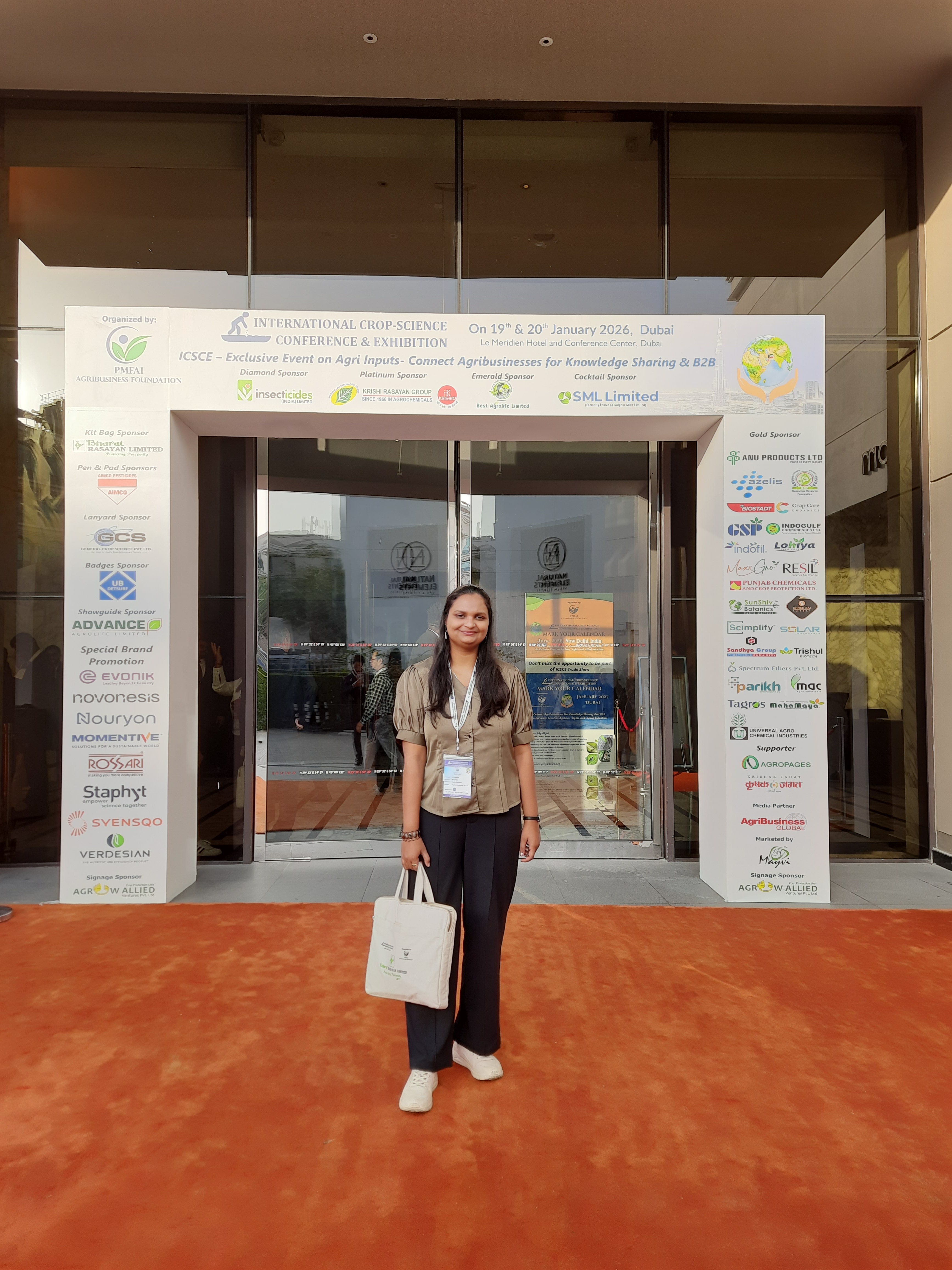 Conference delegate standing before the PMFAI conference display in Dubai.